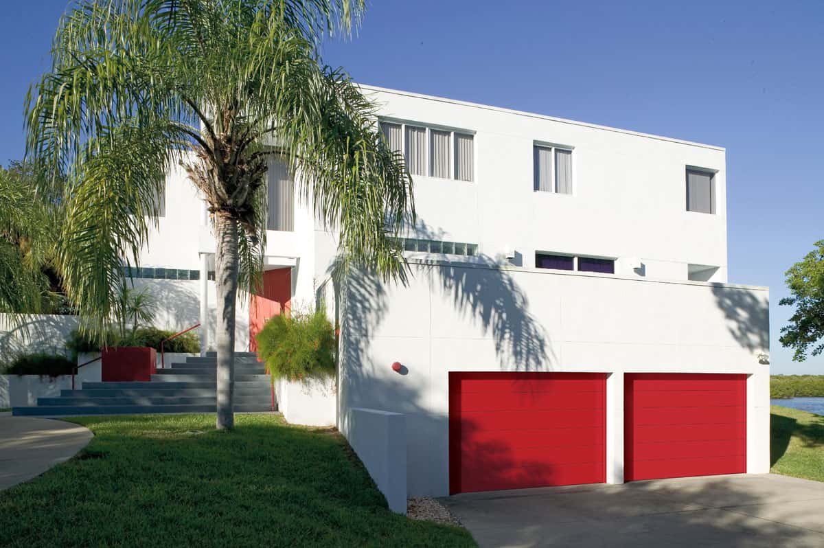 White house with a red, flush panel garage door